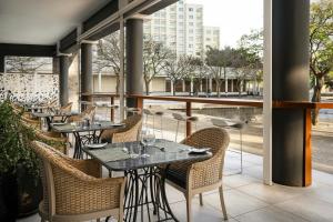 a row of tables and chairs at a restaurant at Protea Hotel by Marriott Cape Town North Wharf in Cape Town