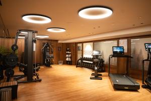 ein Fitnessstudio mit mehreren Laufbändern und Geräten in einem Raum in der Unterkunft The Oswald Grand Hotel in Wolkenstein in Gröden