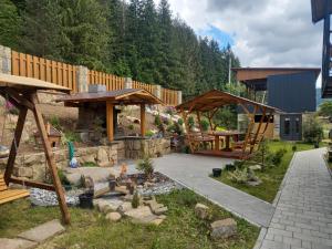 a garden with a patio and a wooden pavilion at Шепіт Лісу in Yaremche
