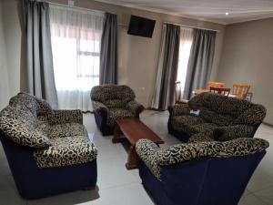 a living room with two chairs and a table at The Grand Village in Mahikeng