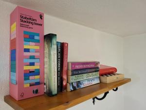 a shelf with a bunch of books on it at Apartma Oliva in Koper