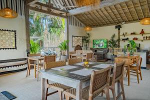 a dining room with a table and chairs at Sacred Padi Ubud Villa in Payangan