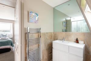 a bathroom with a sink and a mirror at 3 Bed Stylish Beachfront Retreat in Roche +55 photos