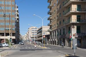 a city street with buildings and people crossing the street at Apartment Sonnino 37 in Cagliari