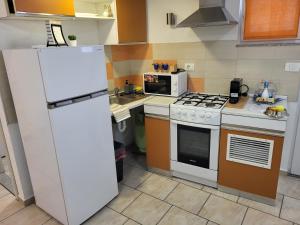 a kitchen with a white refrigerator and a stove at Apartma Oliva in Koper
