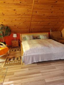 a bedroom with a bed and a wooden ceiling at Őrségi Lápréti Vendégház in Szőce