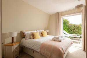 a bedroom with a bed and a large window at 3 Bed Stylish Beachfront Retreat in Roche