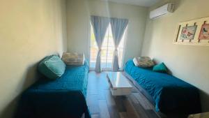 a room with two beds and a window at Coty B in Saladillo