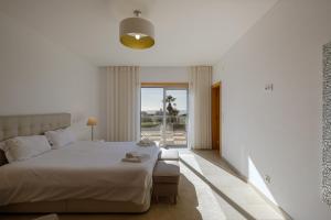 a bedroom with a large white bed and a window at Marvellous Villa in Óbidos
