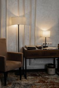 a desk with a lamp and a chair in a room at Dostyk Mildom Almaty in Almaty