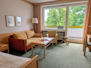 a living room with a couch and a table at Kneippkurhaus St Josef in Bad Wörishofen +23 photos