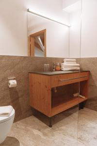 a bathroom with a sink and a toilet and a mirror at Terravita in Fiss +25 photos