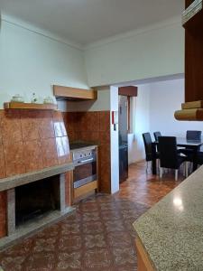 a kitchen with a fireplace and a dining room at Serra Viva in Cortes do Meio