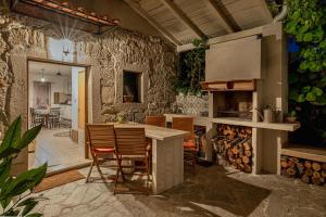 a kitchen with a table and chairs and a stone wall at Holiday House Rea with BBQ and two terrace in Sveti Donat