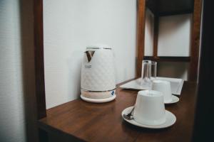 a coffee maker on a wooden counter with two cups at Belvédère Hôtel in Toliara