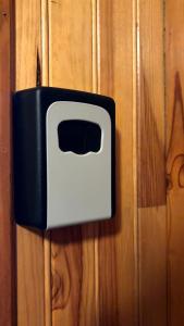 a black and white electrical switch on a wooden wall at Chez So Orcieres in Orcières