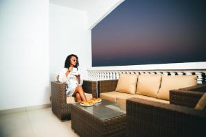 a woman sitting on a chair talking on a cell phone at Belvédère Hôtel in Toliara