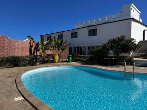 a large blue swimming pool in front of a building at Belvédère Hôtel in Toliara