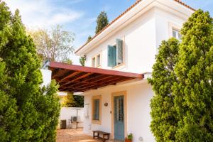 a white house with a green door and trees at Villa Serenity in Neo Chorio