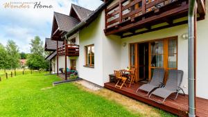 a house with a deck with a table and chairs at Wonder Home - Domki górskie z kominkami na kameralnym osiedlu - plac zabaw na terenie kompleksu in Karpacz