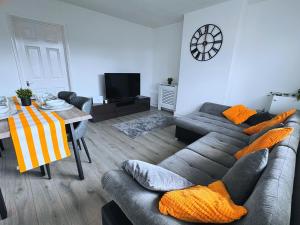 a living room with a couch and a table at Spacious 3 Bed House in Northampton - Sleeps 6 - Driveway Parking - Fast WiFi in Kingsthorpe