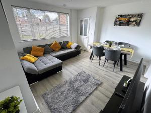 a living room with a couch and a table at Spacious 3 Bed House in Northampton - Sleeps 6 - Driveway Parking - Fast WiFi in Kingsthorpe