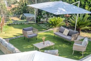 a patio with chairs and a table and an umbrella at Grania Le Radici - Agriresort in Gragnano