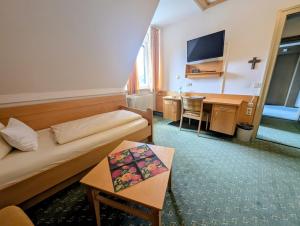 a hotel room with a bed and a desk at Kneippkurhaus St Josef in Bad Wörishofen