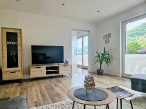 a living room with a television and a table at Ferienwohnung am Weingarten in Ernst