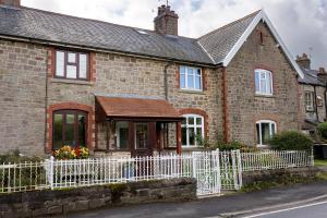 a brick house with a white fence at Vera's cottage in Edale