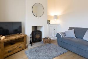 a living room with a blue couch and a fireplace at Vera's cottage in Edale