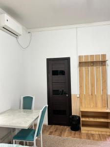 a room with a table and chairs and a black door at Sayak hotel & hostel in Karakol