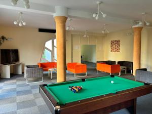 a living room with a pool table and couches at Grantek Üdülőház in Balatonlelle