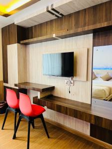 a bedroom with two red chairs and a desk and a bed at Pine Tree Resort in Nagarkot