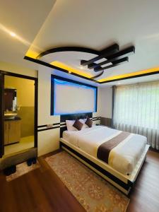 a bedroom with a large bed with a ceiling at Pine Tree Resort in Nagarkot