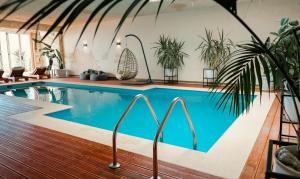 a swimming pool in a room with plants at Festim Villa Hotel in Kaninë