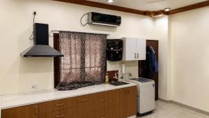 a kitchen with a sink and a microwave and a stove at Maple studio in Patna