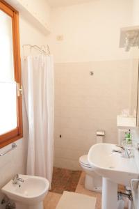 a white bathroom with a toilet and a sink at Il Melo in Fivizzano