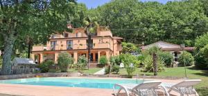 a villa with a swimming pool in front of a house at Villa el Pavo Real Arezzo in Arezzo