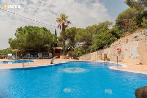 a large blue swimming pool in a resort at Sènia Botànic Bonavista in Calella