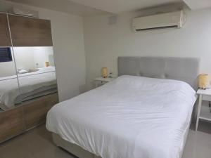 a bedroom with a white bed and a mirror at Tony Guesthouse in Acre