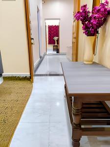 a hallway with a table and flowers in a vase at Ratnadeep Palace - Near Kashi Vishwanath Temple & Ghats in Varanasi