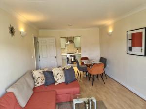 a living room with a red couch and a kitchen at Hunters Wharf River View by Select SA in Reading +45 photos