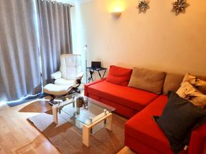 a living room with a red couch and a chair at Hunters Wharf River View by Select SA in Reading