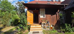 a small house with an orange door and stairs at Pod Lasem in Zwierzyniec