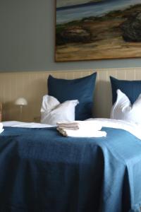 a blue bed with a towel on top of it at Lønstrup Strandhotel in Lønstrup