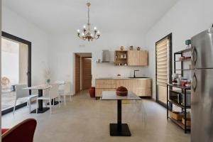 a kitchen and dining room with a table and a refrigerator at ByAma Holiday House in Menfi