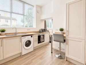 a kitchen with a washing machine and a sink at Modern new redeveloped studio Apartment in Clacton in Clacton-on-Sea