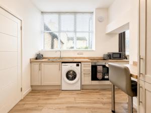 a kitchen with a washing machine and a sink at Modern new redeveloped studio Apartment in Clacton in Clacton-on-Sea