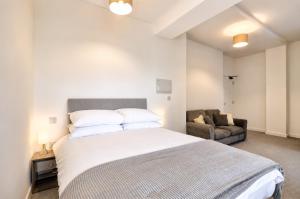 a bedroom with a large bed and a couch at Modern new redeveloped studio Apartment in Clacton in Clacton-on-Sea +13 photos